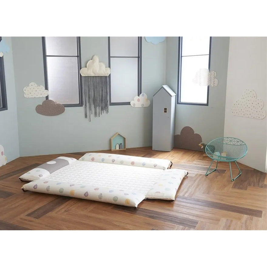 Creamhaus Inua Bumper Bed Guard XL on a pastel nursery floor, showing padded side rails for toddler transition.