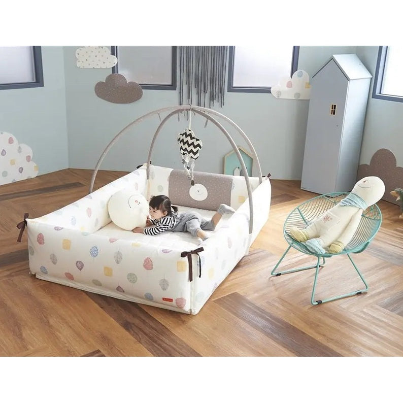Creamhaus Inua Bumper Bed Guard XL: pastel-print bumper bed with arched frame, baby lounging inside.