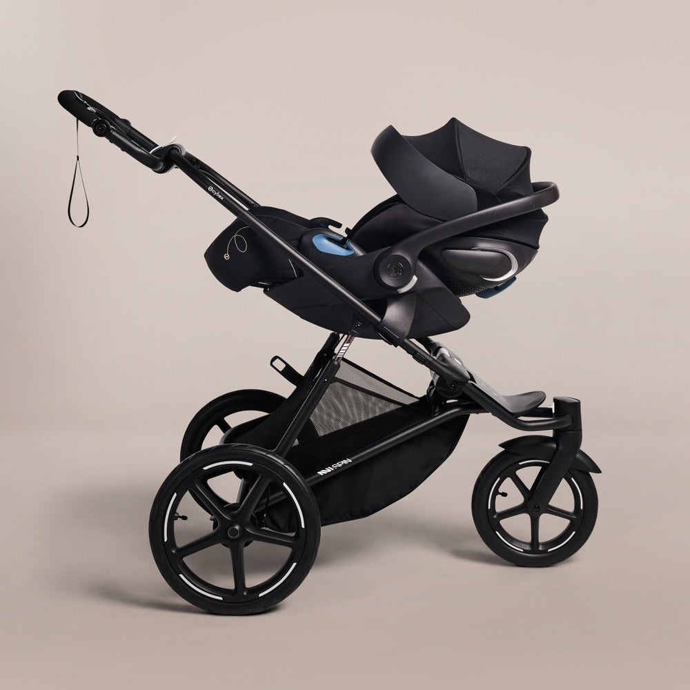 Cybex Avi Spin All Terrain Stroller in black with large 5‑spoke wheels and bassinet attachment.
