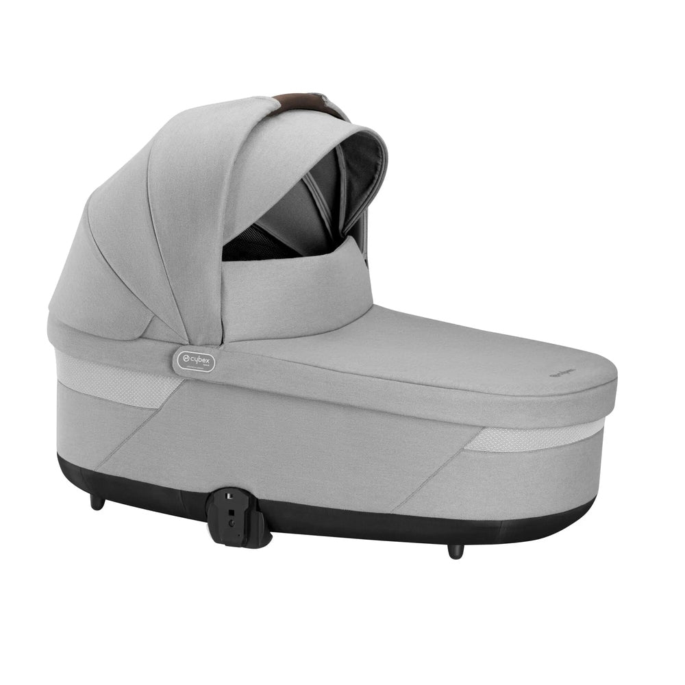 Cybex Balios S Lux Cot bassinet in light gray fabric with an upraised canopy over a padded bassinet and black base.