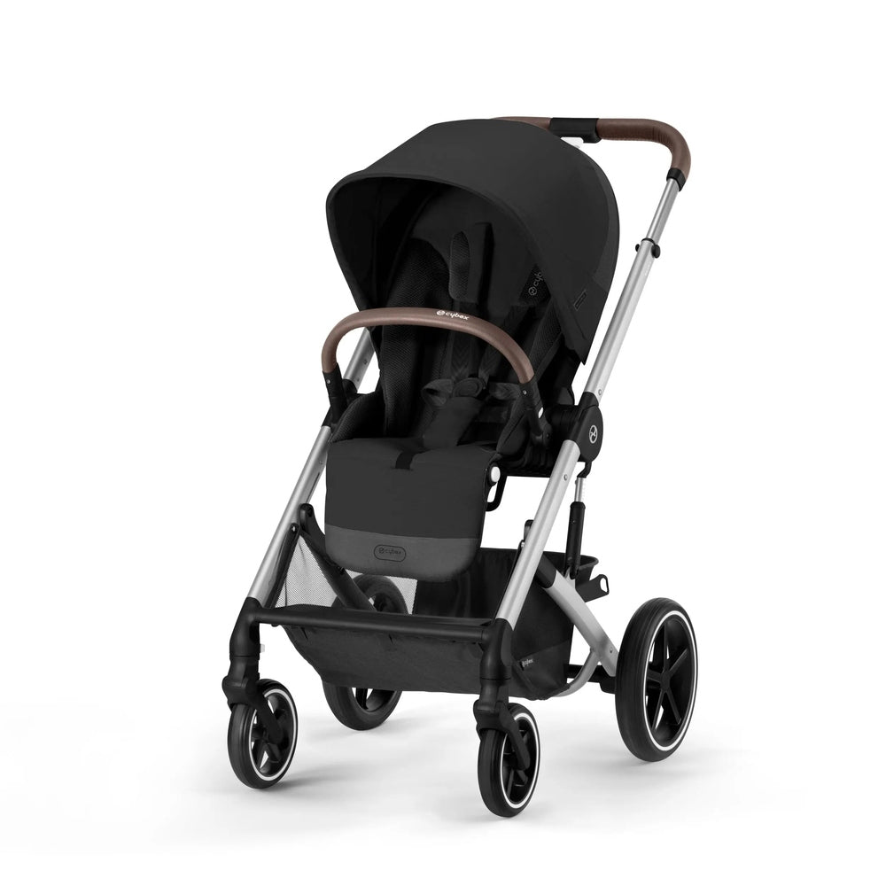 Cybex Balios S Lux Stroller in black with brown leather handlebar and silver frame, being steered with a roomy seat.