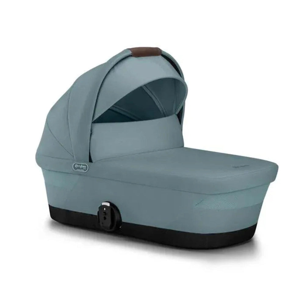 Close-up of the Cybex Gazelle S V2 Cot stormy blue fabric bassinet for stroller with black base and brown leather-accent handle.