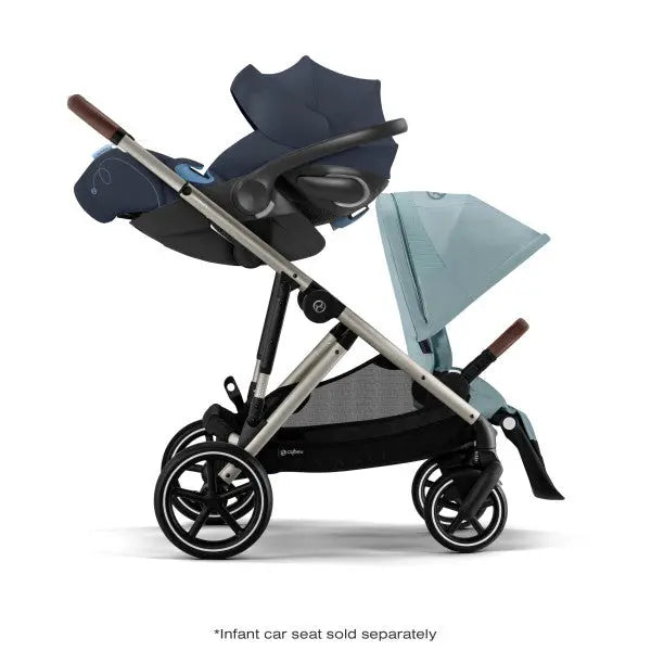 Cybex Gazelle S V2 stroller with navy bassinet and light-blue canopy, aluminum frame, brown handles; ready for a smooth stroll.