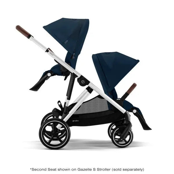 Cybex Gazelle S V2 Toddler Stroller with dual navy seats and brown leatherette handles, silver frame in action.