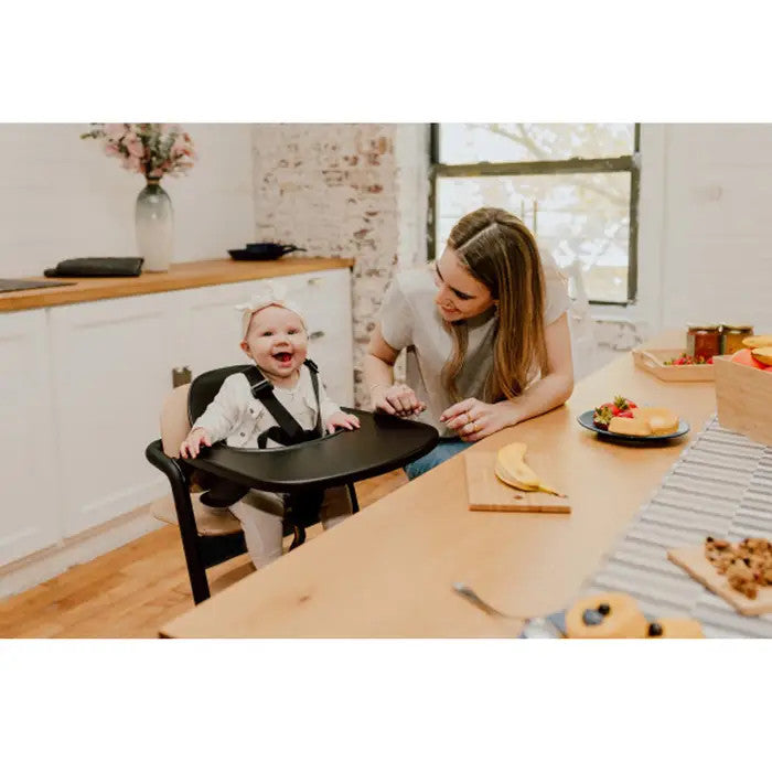CYBEX Lemo 3-in-1 high chair with training tower in Sand Black; baby seated in chair with mother at a kitchen table.