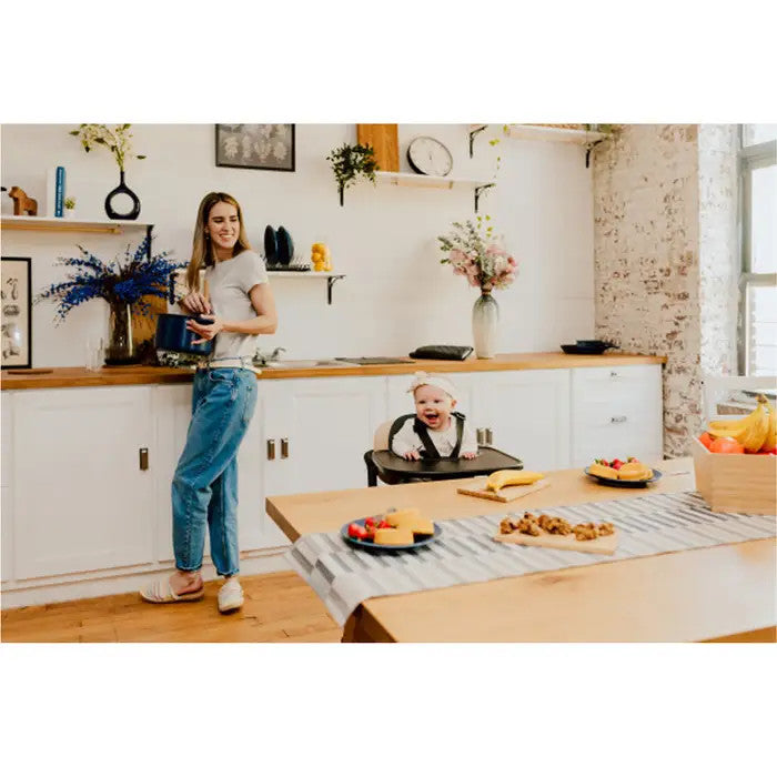 Cybex Lemo 3-in-1 high chair and training tower set in Sand Black with baby in high chair in a bright kitchen.