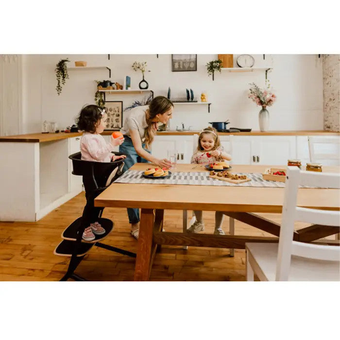 CYBEX Lemo 3-in-1 high chair with training tower in sand black at a family kitchen table with children