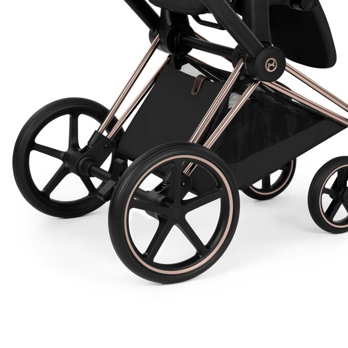 Cybex Platinum Priam 5 Luxury Stroller close-up of the large rear wheels, rose gold frame, and underseat basket.