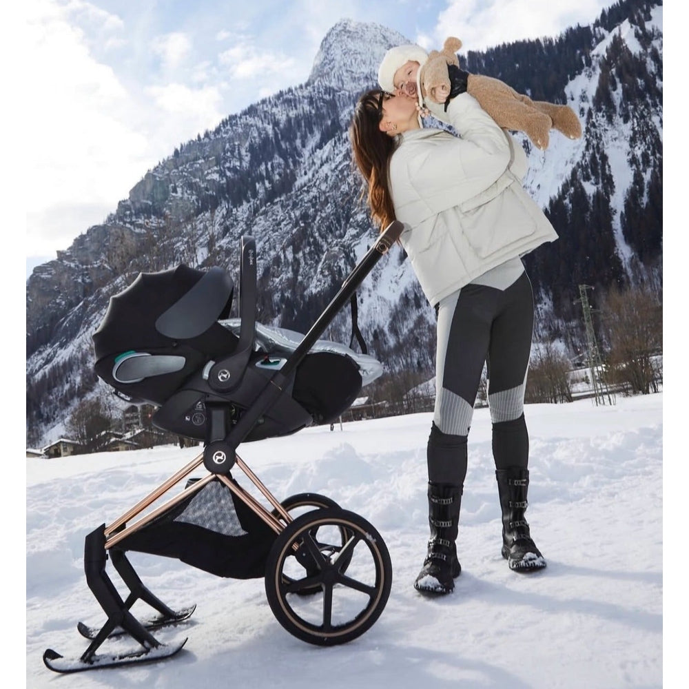 CYBEX Priam 4 stroller with Lux carry cot in sepia black on rose-gold frame, snowy mountain backdrop