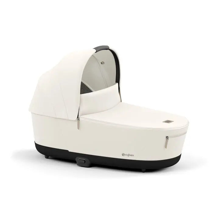 Cybex Priam Lux Carry Cot white with extended canopy, securely attached to the Priam Lux stroller chassis.