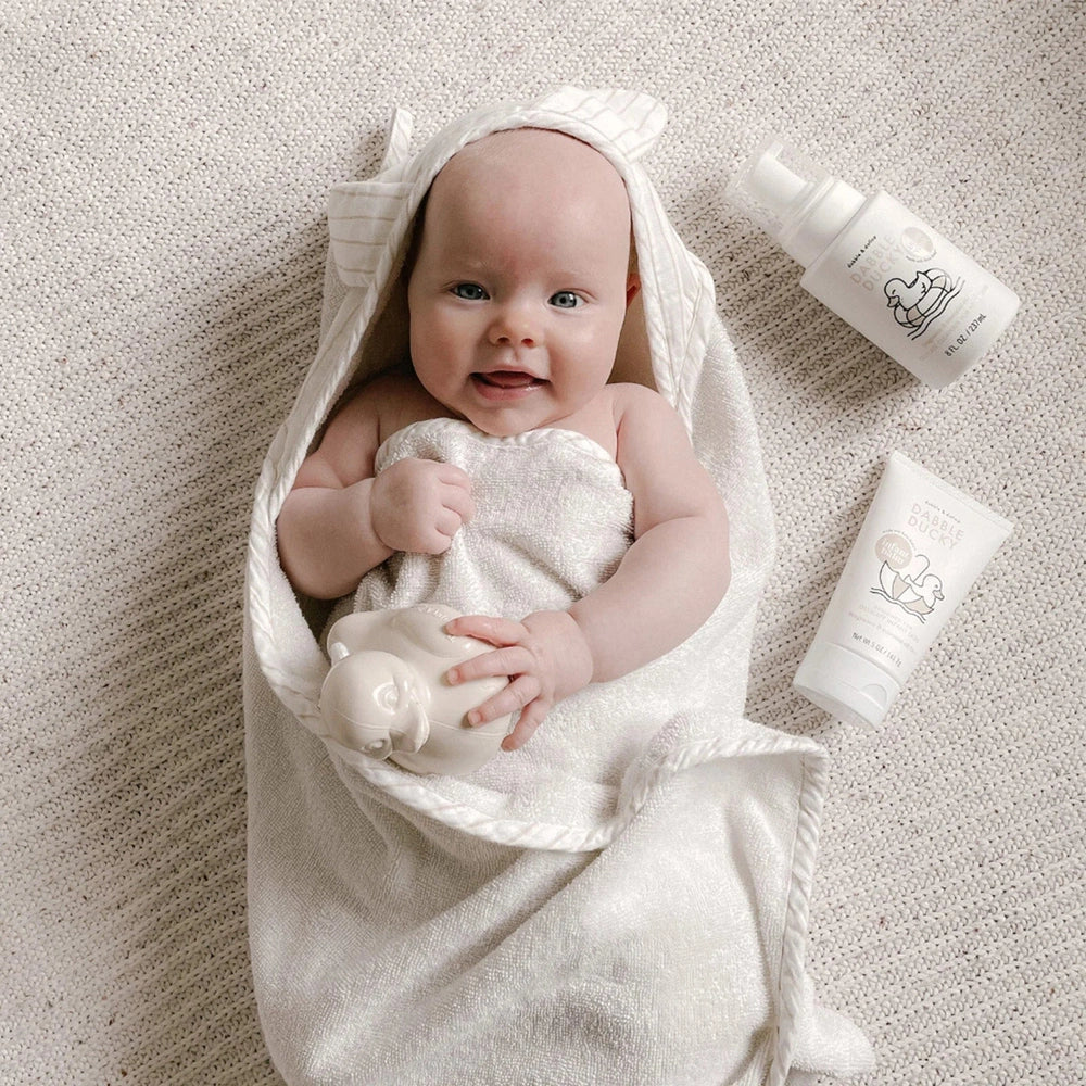 Dabble & Dollop All-Natural Infant Balm fragrance-free; baby snug in white towel with balm bottle and tube nearby