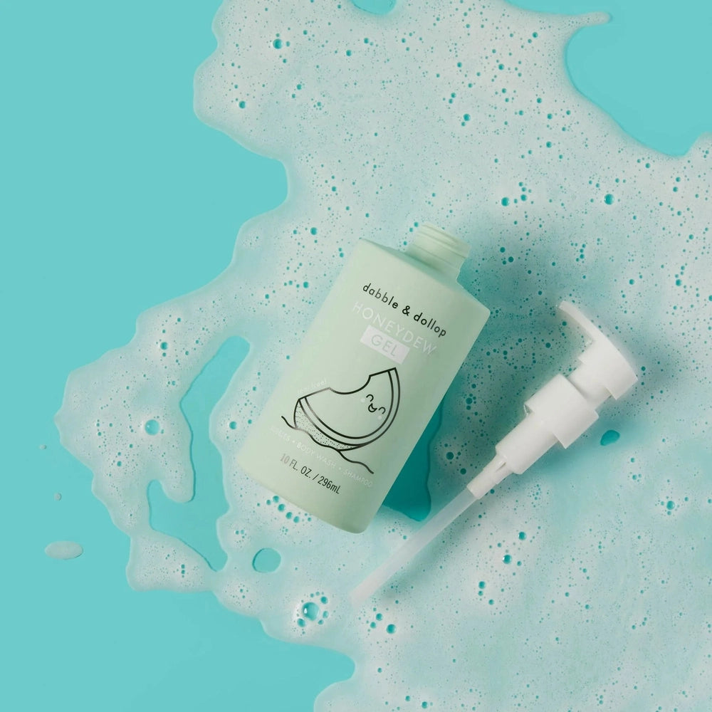 Dabble & Dollop All-Natural Shampoo, Body Wash & Bubbles Honeydew bottle with pump amid teal bubbles.
