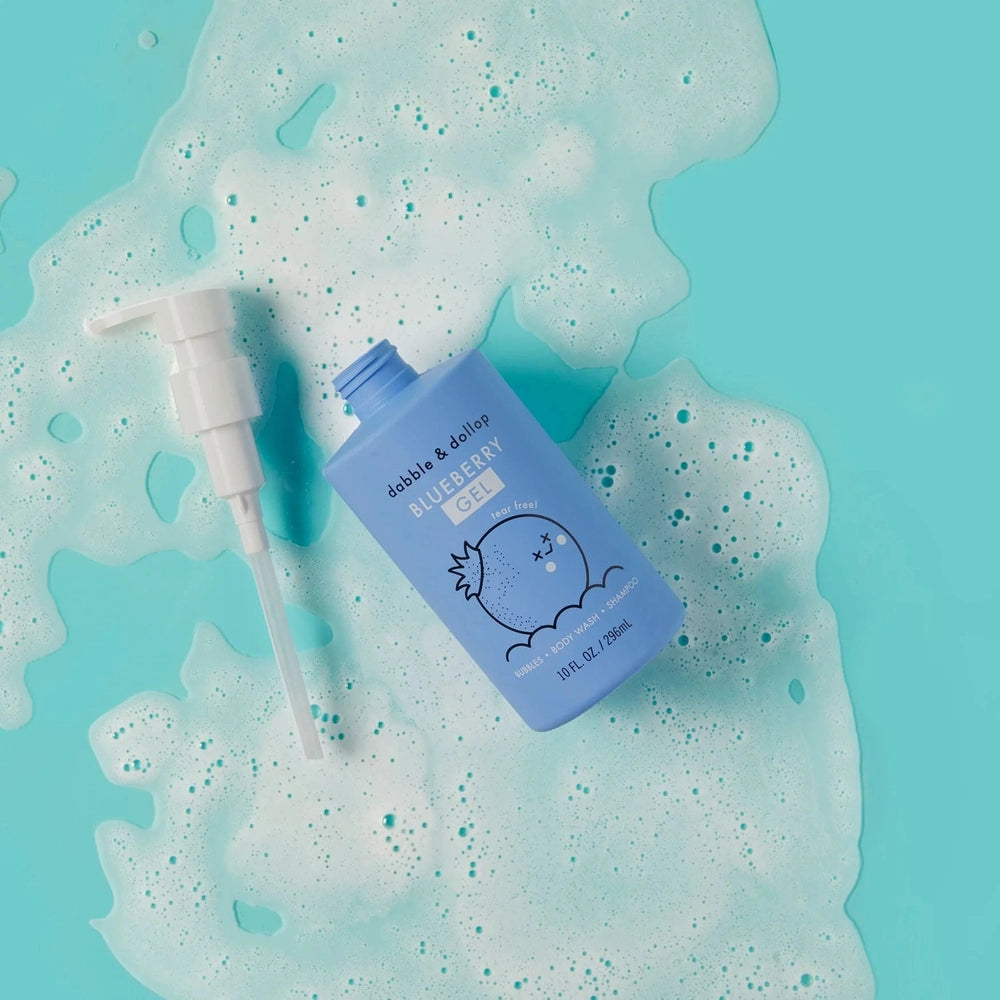 Dabble & Dollop All-Natural Shampoo bottle in blueberry blue with pump, surrounded by frothy bubbles.