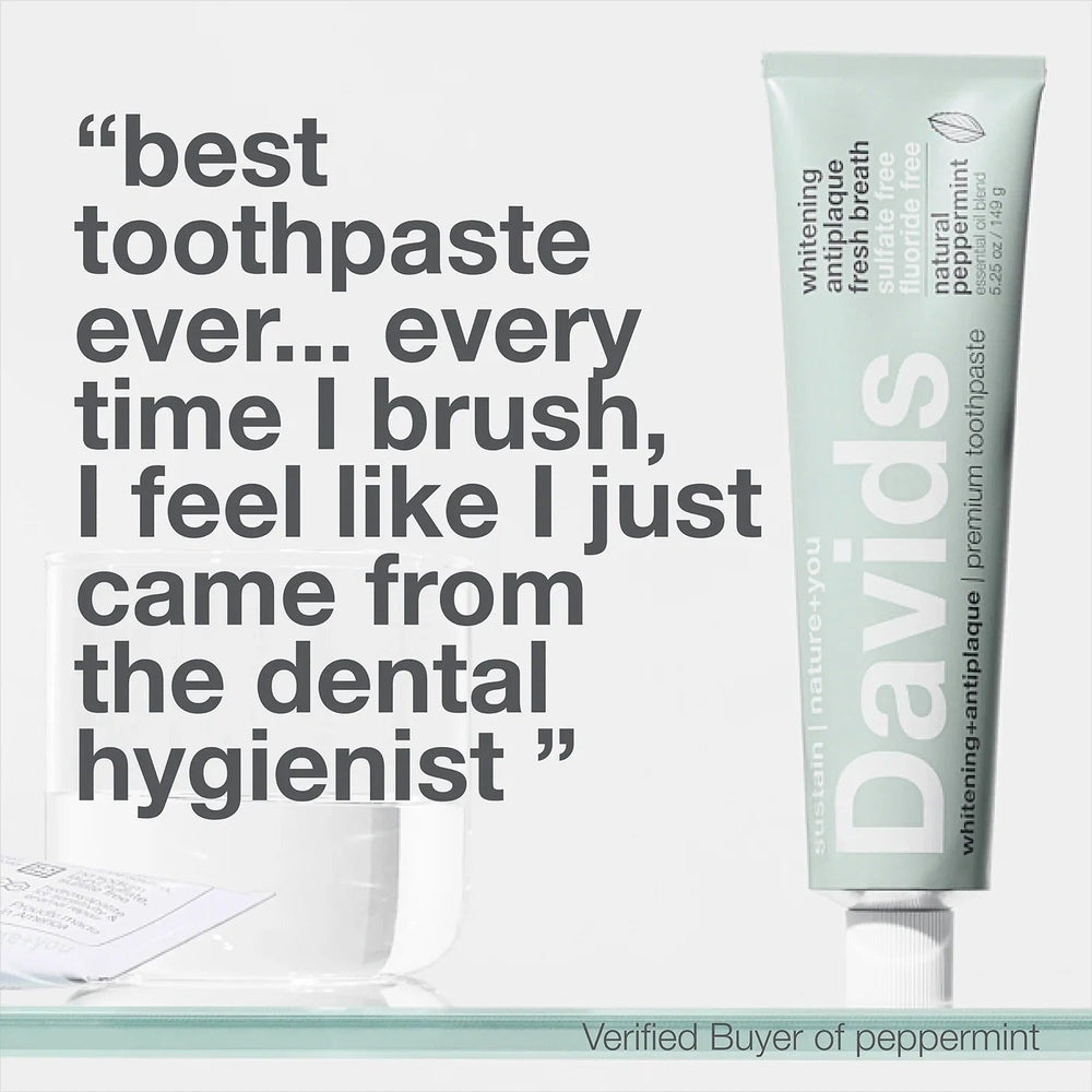 DAVIDS Toothpaste Fluoride Free Peppermint in a mint-green tube standing upright beside a glass.