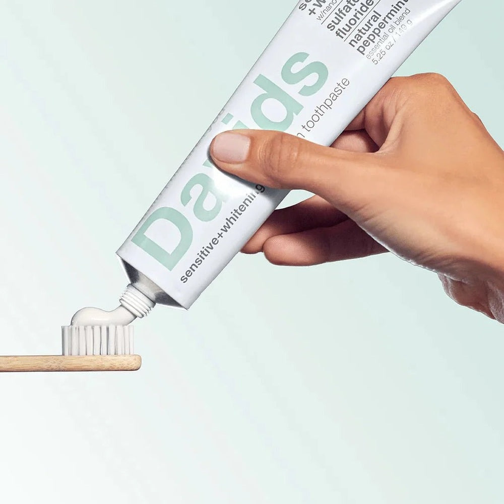 DAVIDS toothpaste Sensitive & Whitening fluoride-free peppermint being squeezed onto a toothbrush.