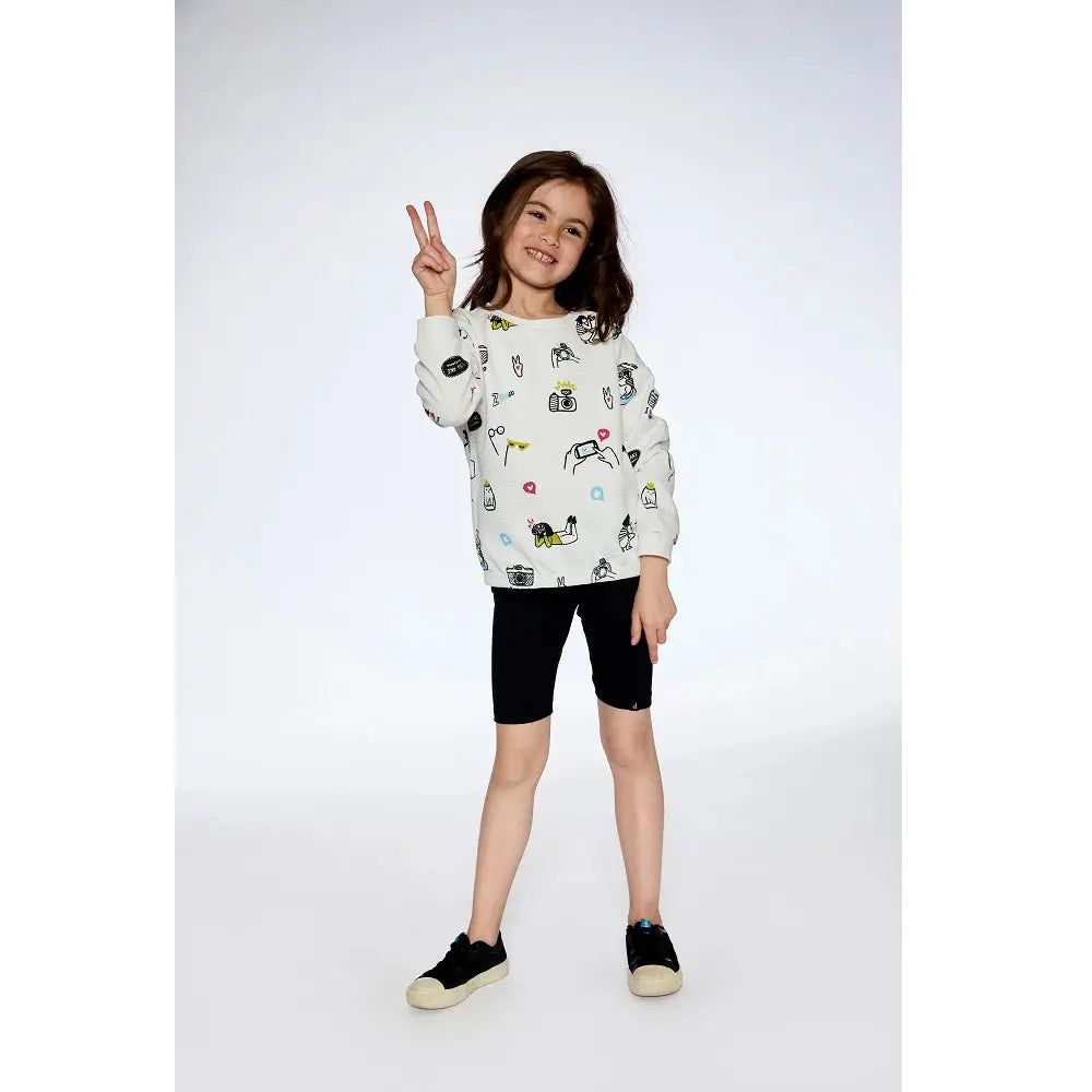 Deux Par Deux Organic Cotton Biker Shorts Black on a smiling girl posing with a peace sign.