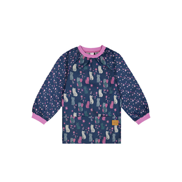 Deux Par Deux school apron worn by a child; navy with pink trim and cat-print sleeves, a long-sleeve smock.