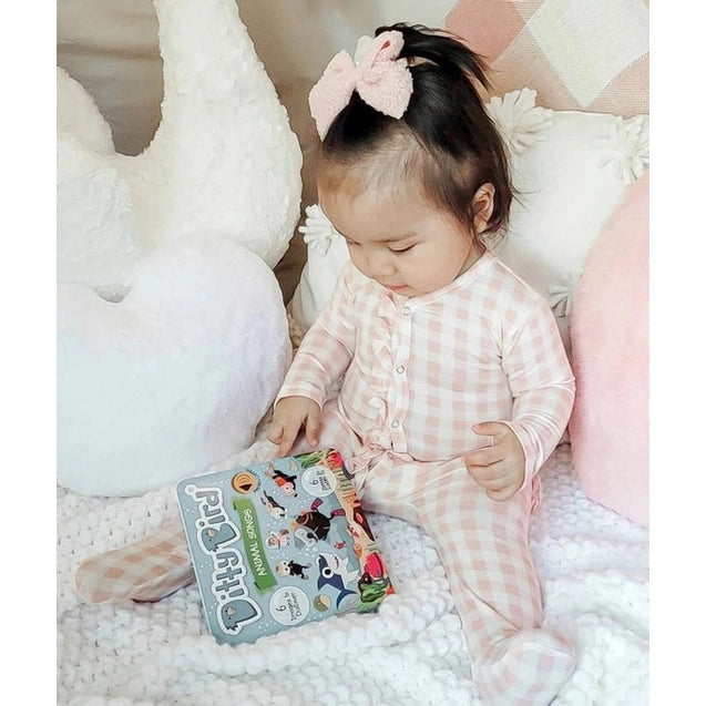 Ditty Bird Sound Book Animal Songs USB-C Rechargeable; baby in pink gingham taps pages on the colorful toy book.