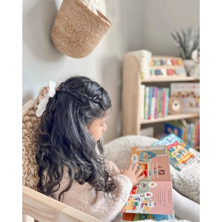 Ditty Bird Sound Book Animal Songs USB-C Rechargeable being read by a child in a cozy reading nook.