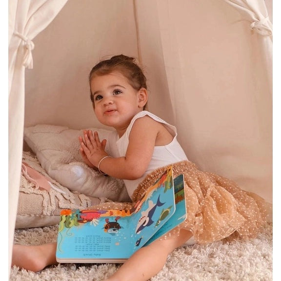 Ditty Bird Sound Book Animal Songs USB-C Rechargeable; toddler sits in a cozy tent reading the colorful book.