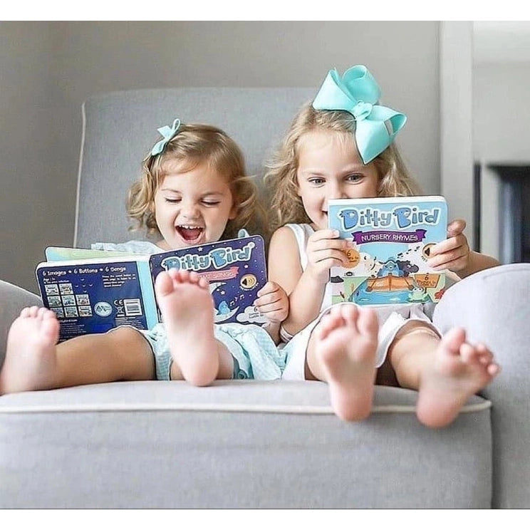 Two little girls on a sofa reading Ditty Bird Sound Book Bedtime Songs USB-C Rechargeable, by DITTY BIRD.