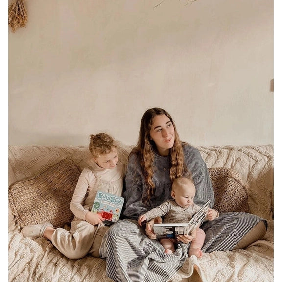 Ditty Bird Sound Book Black and White Animals USB-C Rechargeable, shared by mom and two kids on a cozy couch