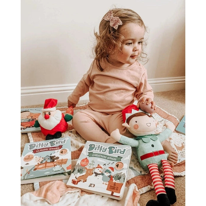Ditty Bird Sound Book Christmas Songs USB-C rechargeable toy beside a toddler with books and elf plush.
