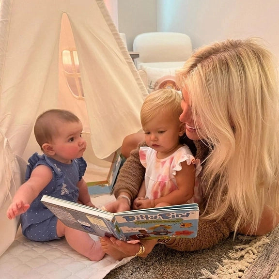 Ditty Bird Sound Book Farm Animal USB-C Rechargeable; a caregiver reads it to two babies on a rug.