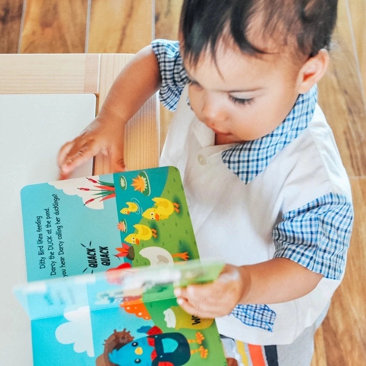 Ditty Bird Sound Book Farm Animal USB-C Rechargeable being read by a toddler, showing bright farm animal illustrations