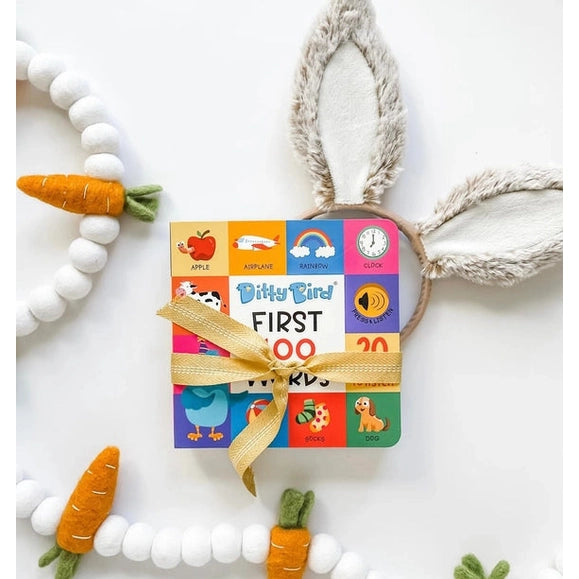 Ditty Bird Sound Book First 100 Words USB-C Rechargeable, colorful panels tied with a ribbon beside plush bunny ears.