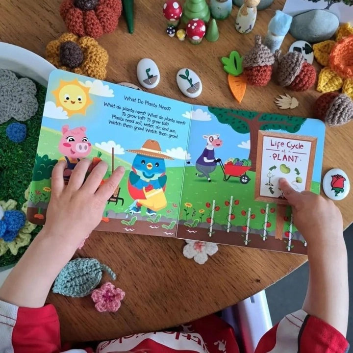 Ditty Bird Sound Book Nature Songs USB-C Rechargeable; child flips through vibrant nature pages.