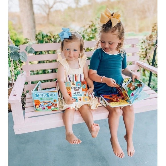 Ditty Bird Sound Book Nature Songs USB-C Rechargeable; two kids read the colorful books on a pink bench.