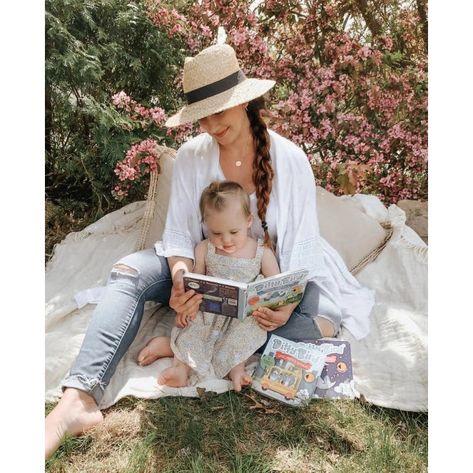 Ditty Bird Sound Book Touch The Cute Animals USB-C Rechargeable, being read by a mom and child on a sunny blanket.