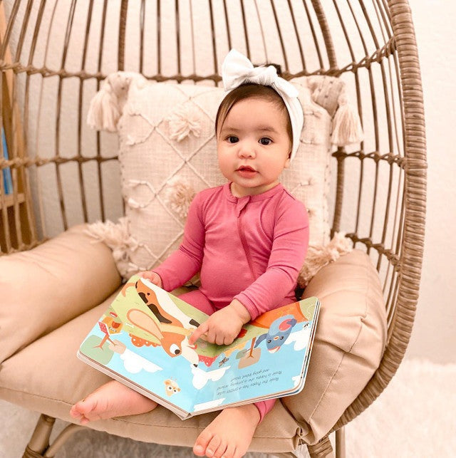 Ditty Bird Sound Book Touch The Cute Animals USB-C Rechargeable being read by a baby in a pink onesie.