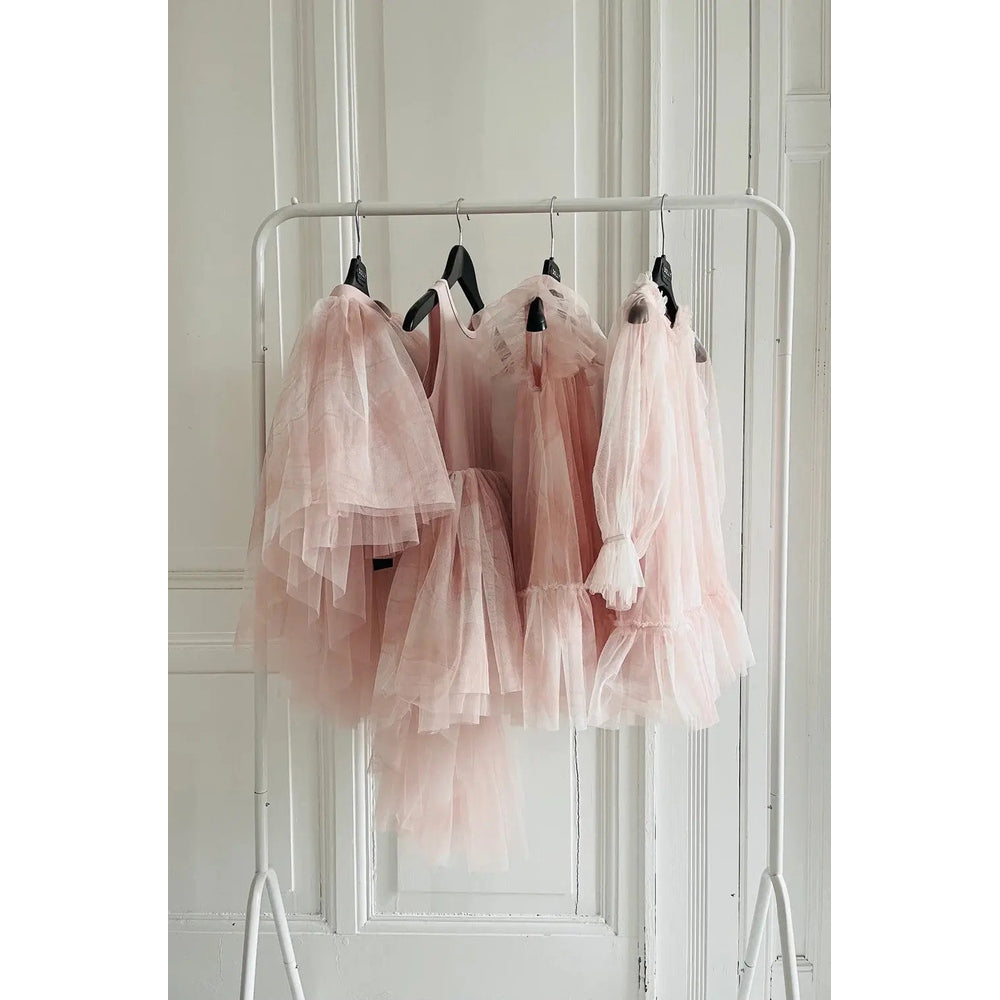Dolly By Le Petit Dreamy Babydoll Puff Dress Pink Clouds; soft pink tulle dresses hanging on a white rack.