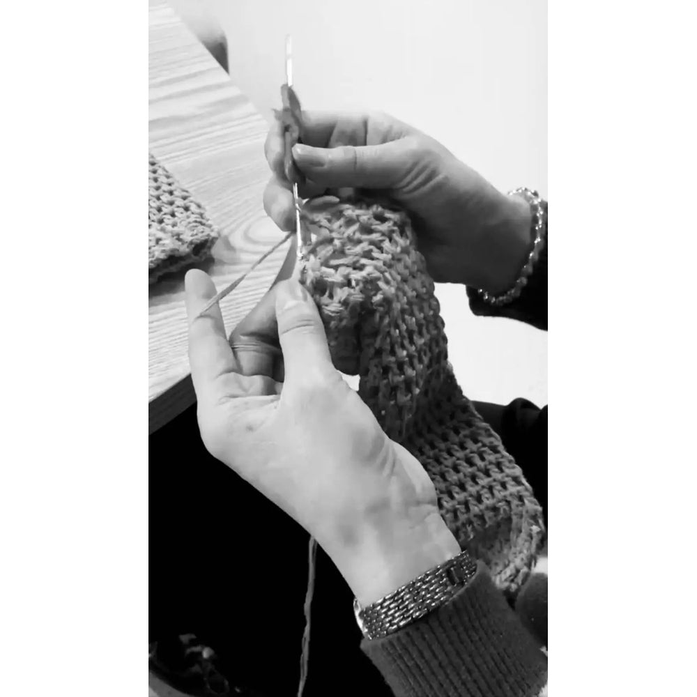 Dolly By Le Petit Tom Crochet Tutu Dress V-Neck Silver Grey, hands crochet the knit on a wooden table.