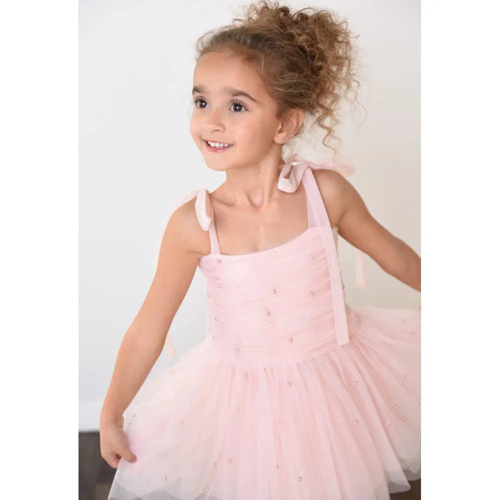 Dolly By Le Petit Tom Pearl Tulle Ballerina Dress in pink with ribbon straps; girl twirls to show pearl embellishments.