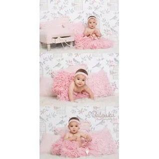 Dolly By Le Petit Tom Queen Of Roses Pettiskirt Rose Pink worn by a baby girl on a plush pink backdrop.