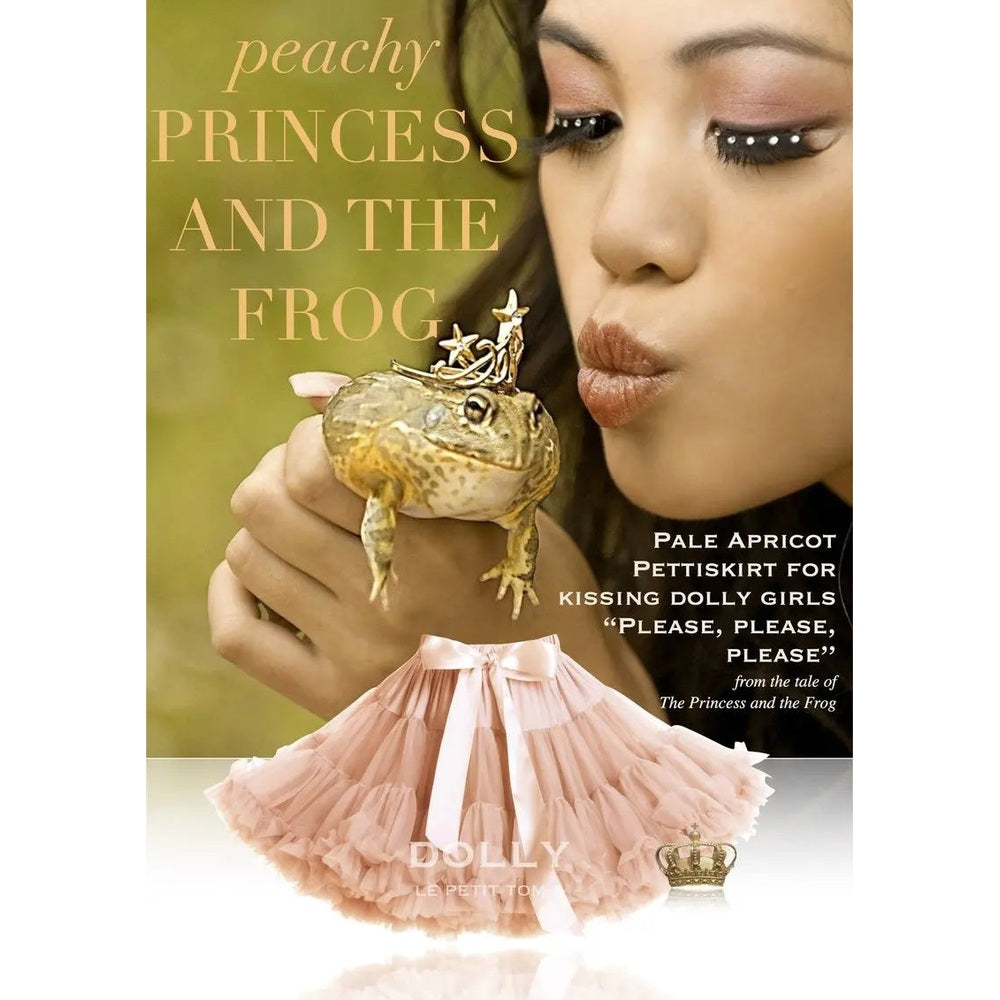 DOLLY PRINCESS & THE FROG Pettiskirt Pale Apricot; a pink tulle tutu displayed beneath a woman kissing a frog prop.