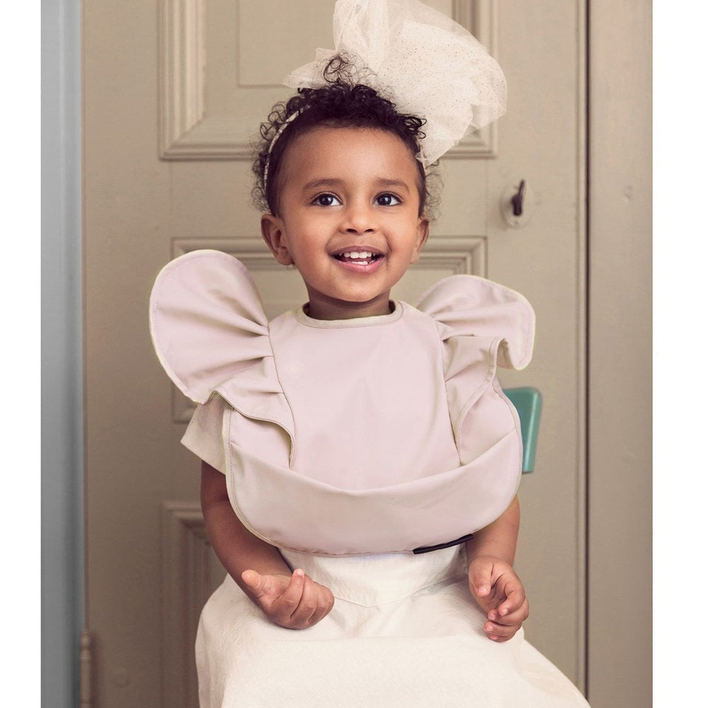 Elodie Details powder pink baby bib with ruffle sleeves for mealtime