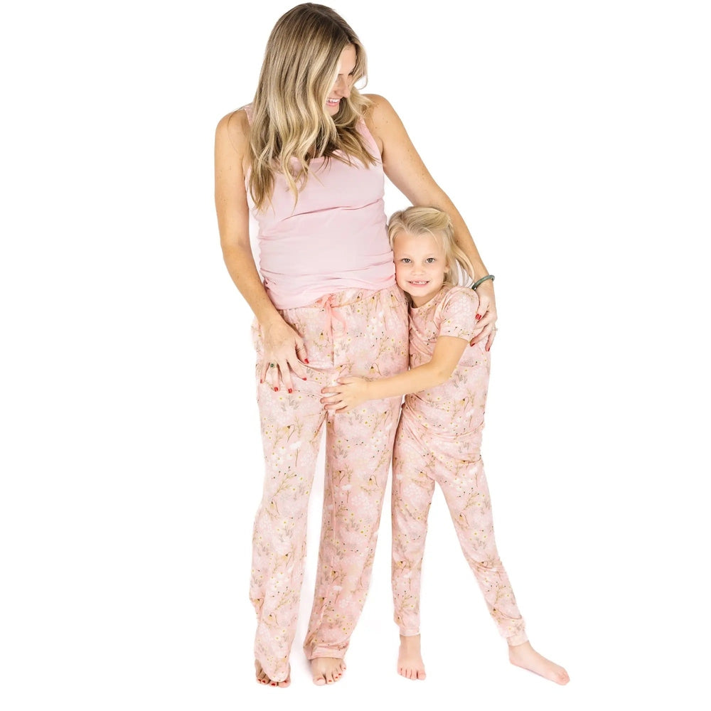 Woman and child wearing matching pink pajamas on a white background