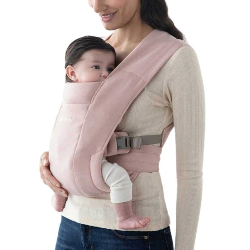ERGOBABY Embrace Newborn Carrier Blush Pink worn by mom carrying a baby in a soft-structured carrier