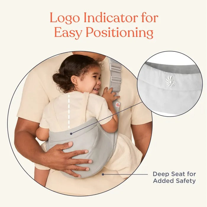 Ergobaby Upsie Sling Carrier in soft gray; child snug in deep-seat carrier as parent supports from behind.