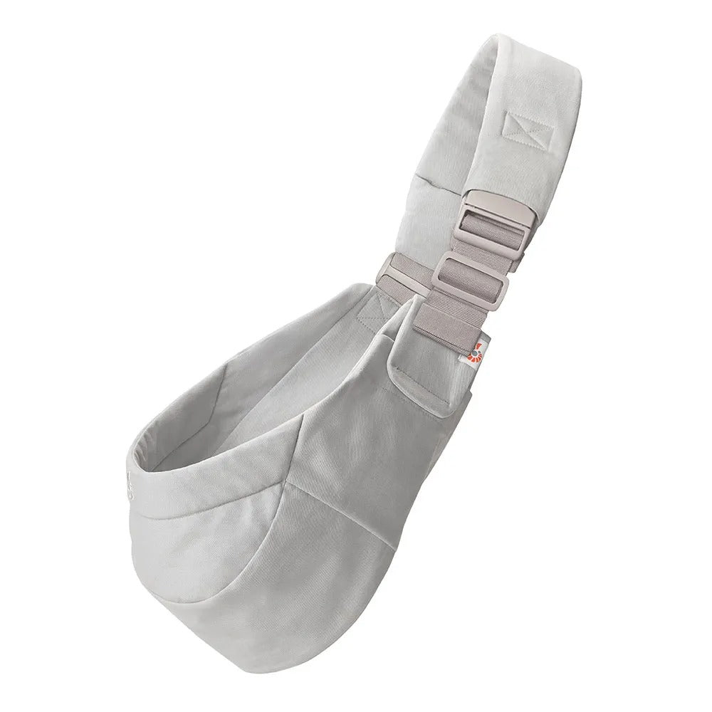 Ergobaby Upsie Sling Carrier in light gray with padded, adjustable straps buckled for hands-free comfort.