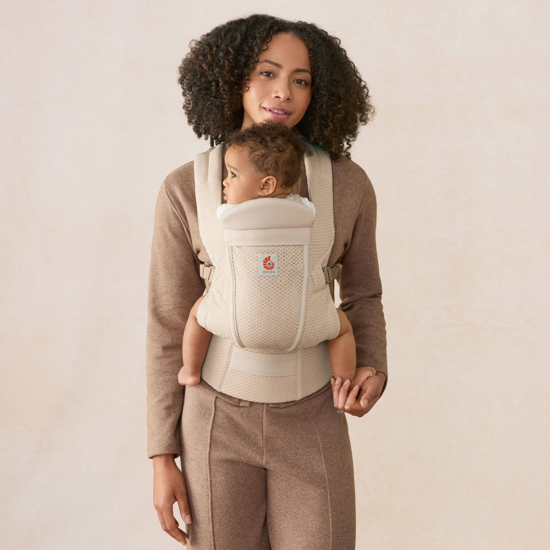 Ergobaby Omni Lite Baby Carrier in Natural Beige, front view worn with baby