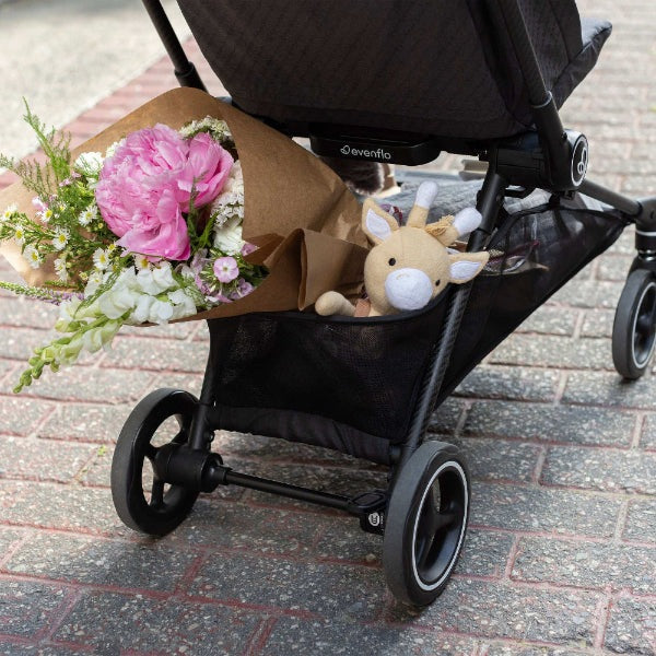 Evenflo Hummingbird carbon fiber stroller with bouquet and plush toy in rear storage basket.