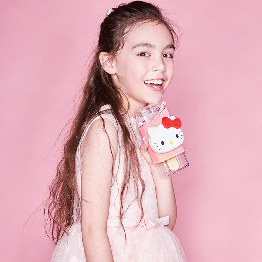 Hello Kitty ice pop water bottle by FamilyOut, pink with clear base, held by smiling girl