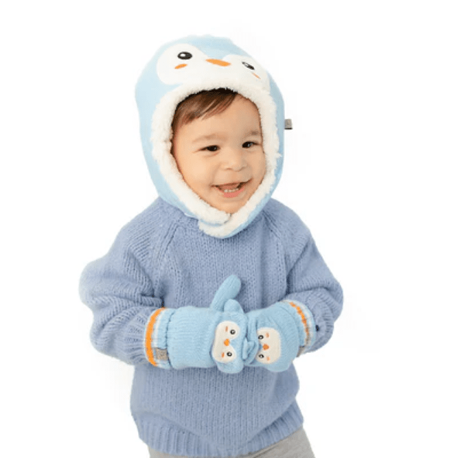 Flapjackkids Baby Knitted Mittens Penguin: a smiling toddler in a blue sweater wears cozy penguin mittens.