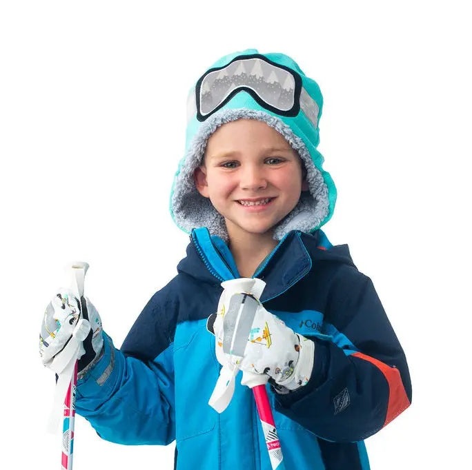 Flapjackkids Reversible Kids Sherpa Hat Wolf & Ski Goggles on a smiling child, turquoise with gray lining, gripping ski poles.