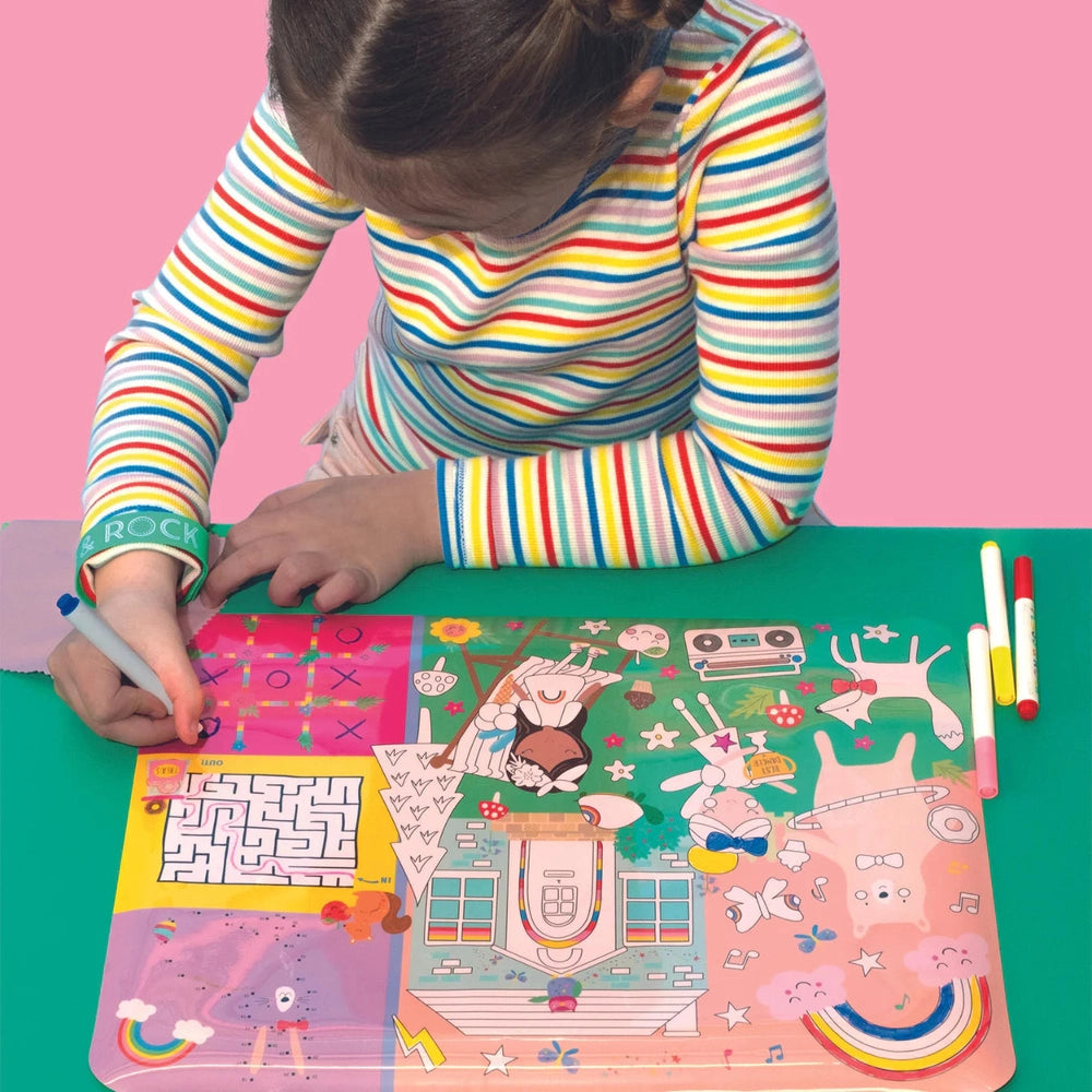 Floss and Rock Colouring Fun and Games Mat, rainbow-colored coloring pad used by a child with markers.